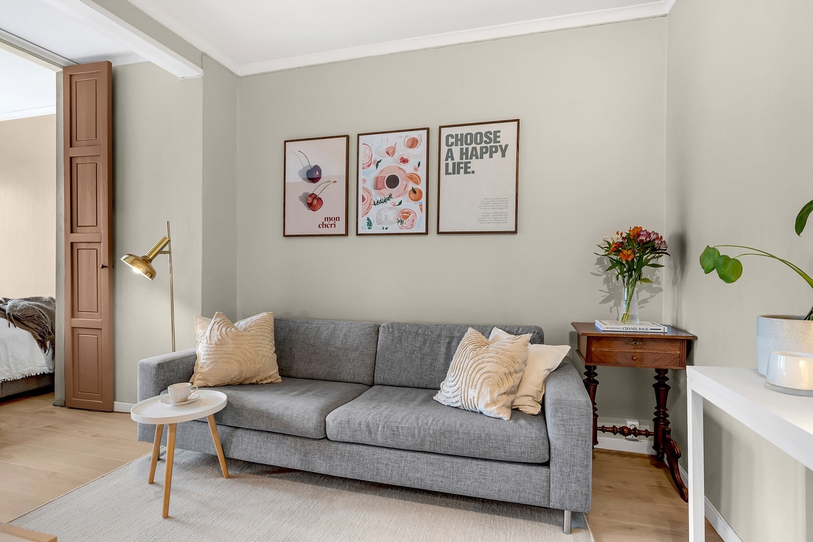 Grå sofa og dekorative bilder gir stuen et stilfullt preg. Galleribilde