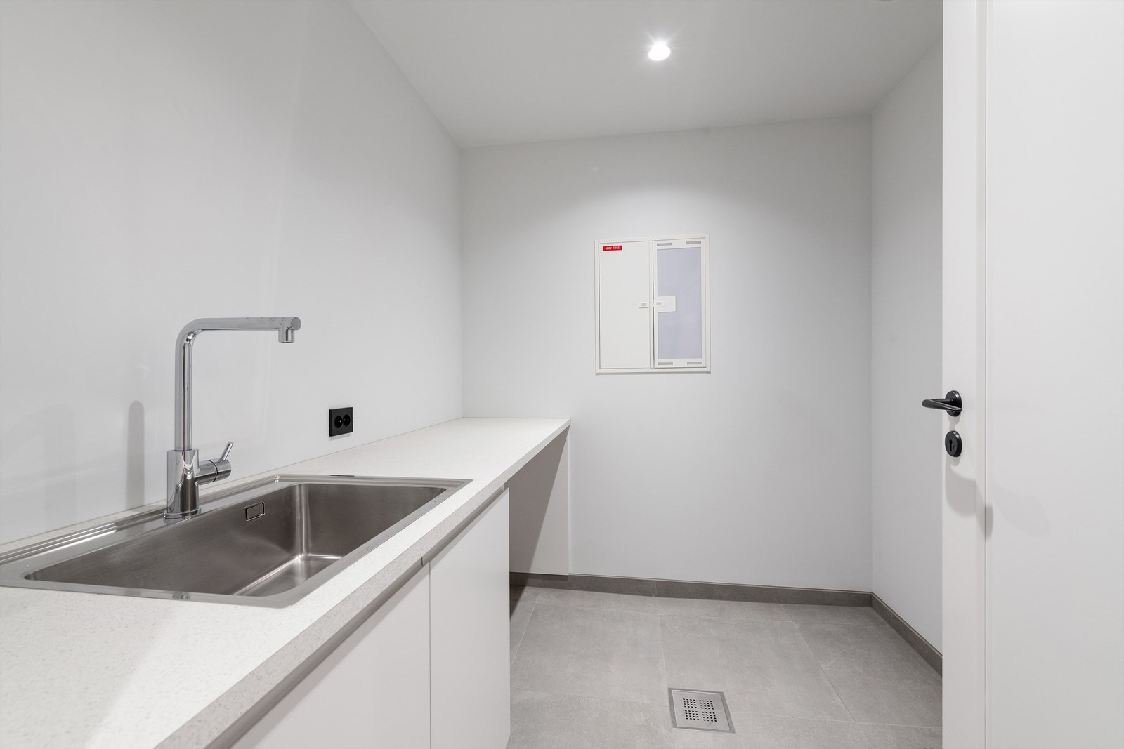 Praktisk vaskerom med utslagsvask og plass til vaskemaskin og tørketrommel. Galleribilde