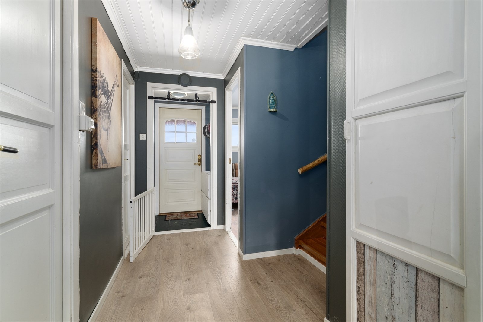 Med adkomst fra det hyggelige inngangspartiet kommer man inn i boligens gangarealer som består av vindfang og gang. I gangen er det moderne laminat på gulvet som går videre inn i stua og kjøkkenet og gir en fin helhet i etasjen. Galleribilde