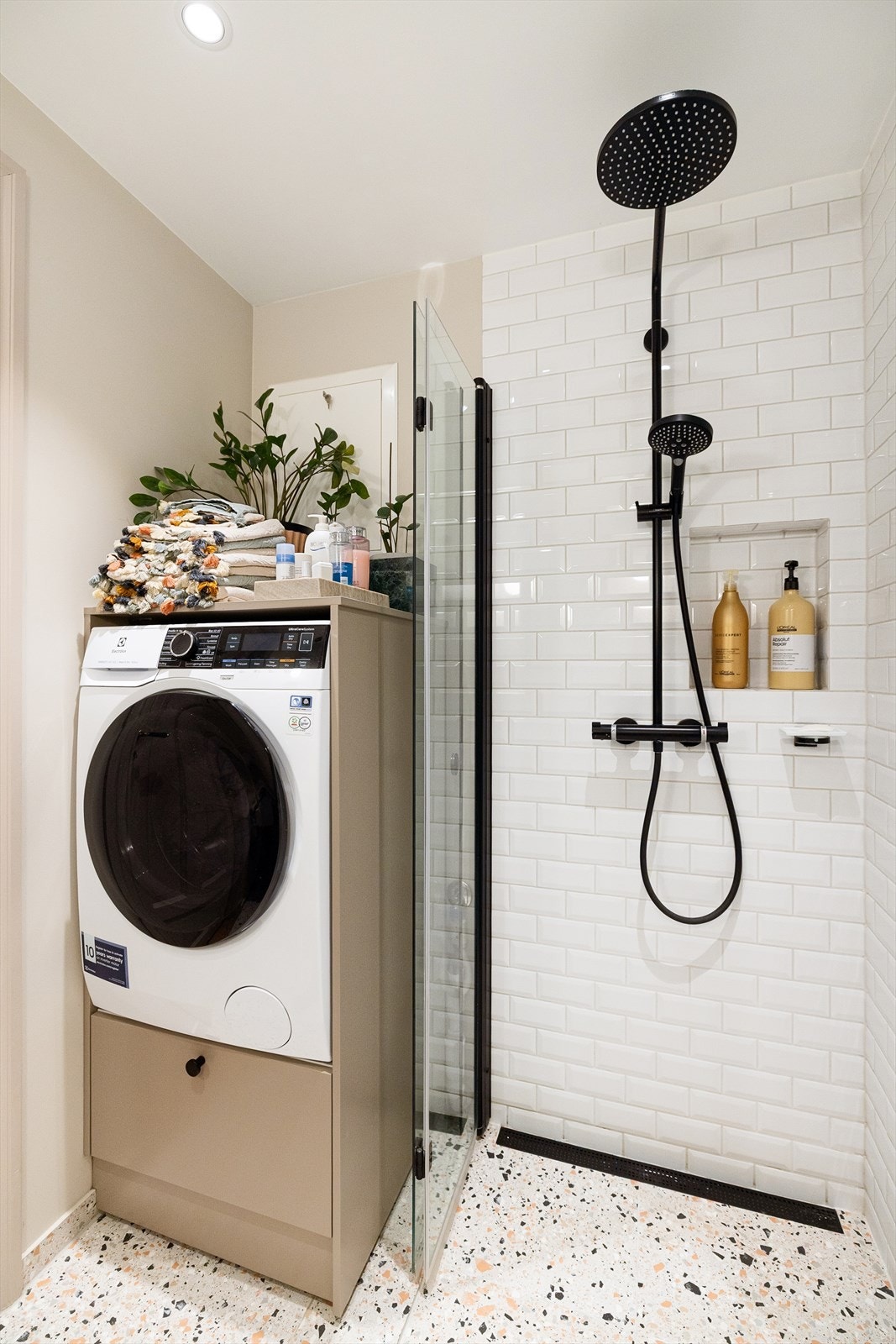 Dusjsonen har innfellbare glassdører, regnfallsdusj og praktisk opplegg for vaskemaskin. Galleribilde