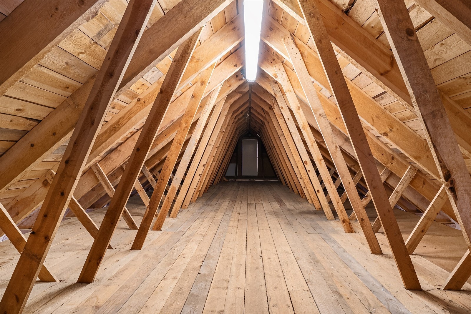 Uinnredet råloft (med adkomst via trapp fra garasje/adkomst via dør fra innredet loft) stedvis kledd med panelbord og synlige taksperrer Galleribilde