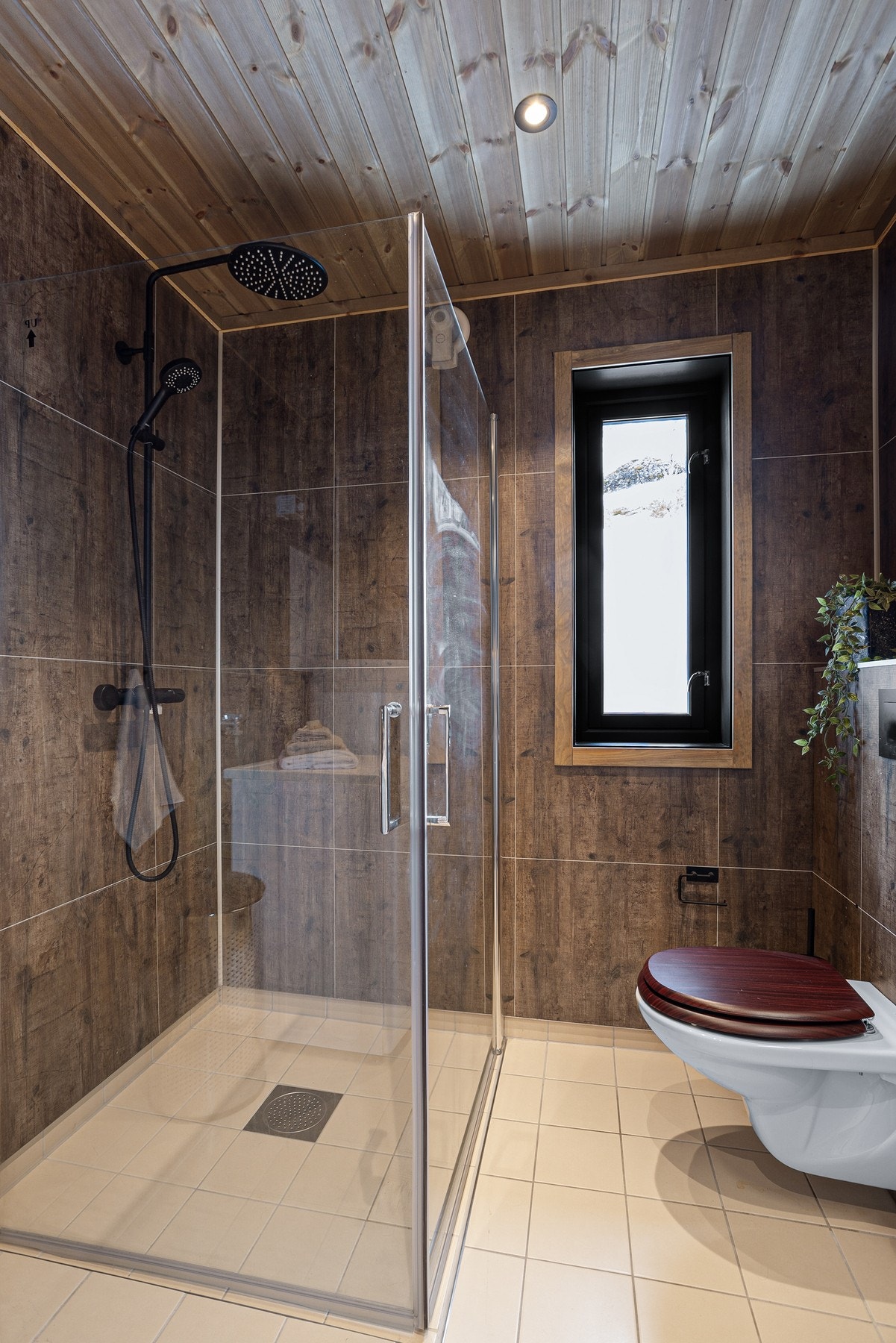 Det er våtromsplater på vegg og flislagt gulv med varmekabler Galleribilde