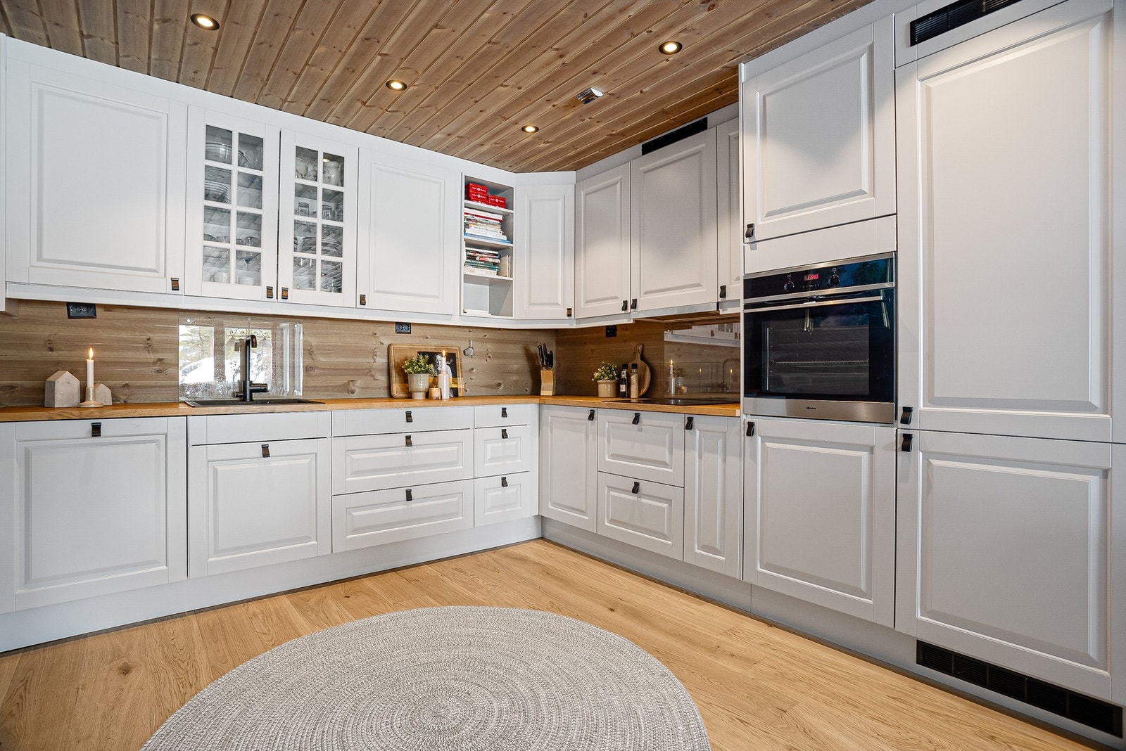 Innredningen består av integrerte hvitevarer som oppvaskmaskin, platetopp, stekeovn i god arbeidshøyde, samt kjøleskap og fryser Galleribilde