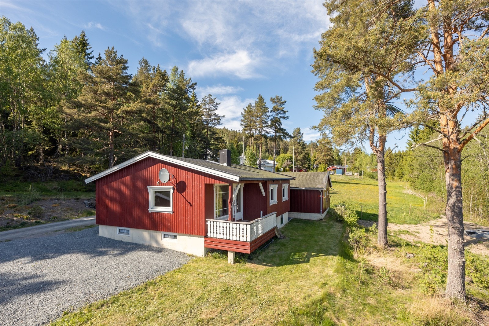 Tomten er opparbeidet med gruset gårdsplass og plen, og grenser til naturtomt. Galleribilde