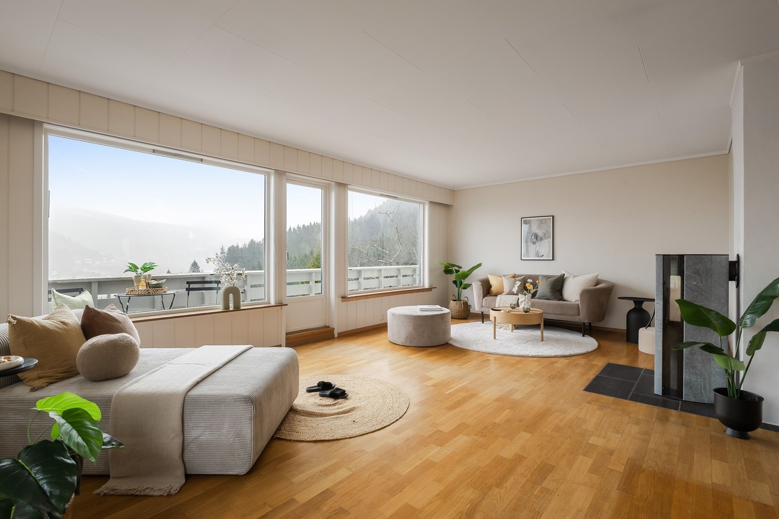 Vi beveger oss inn i hjerte av boligen - En lys og romslig stue med store vindusflater som sørger for gode lysforhold Galleribilde