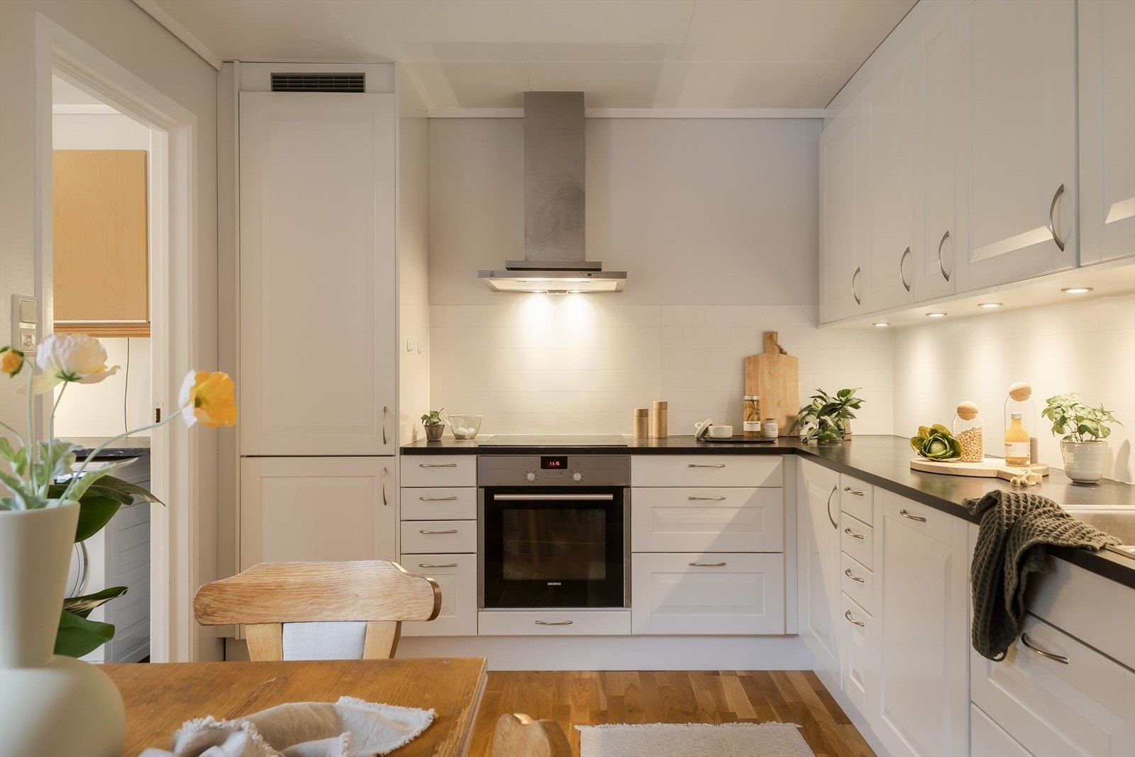 Boligens kjøkken er lyst og pent med profilerte fronter og laminat benkeplate Galleribilde