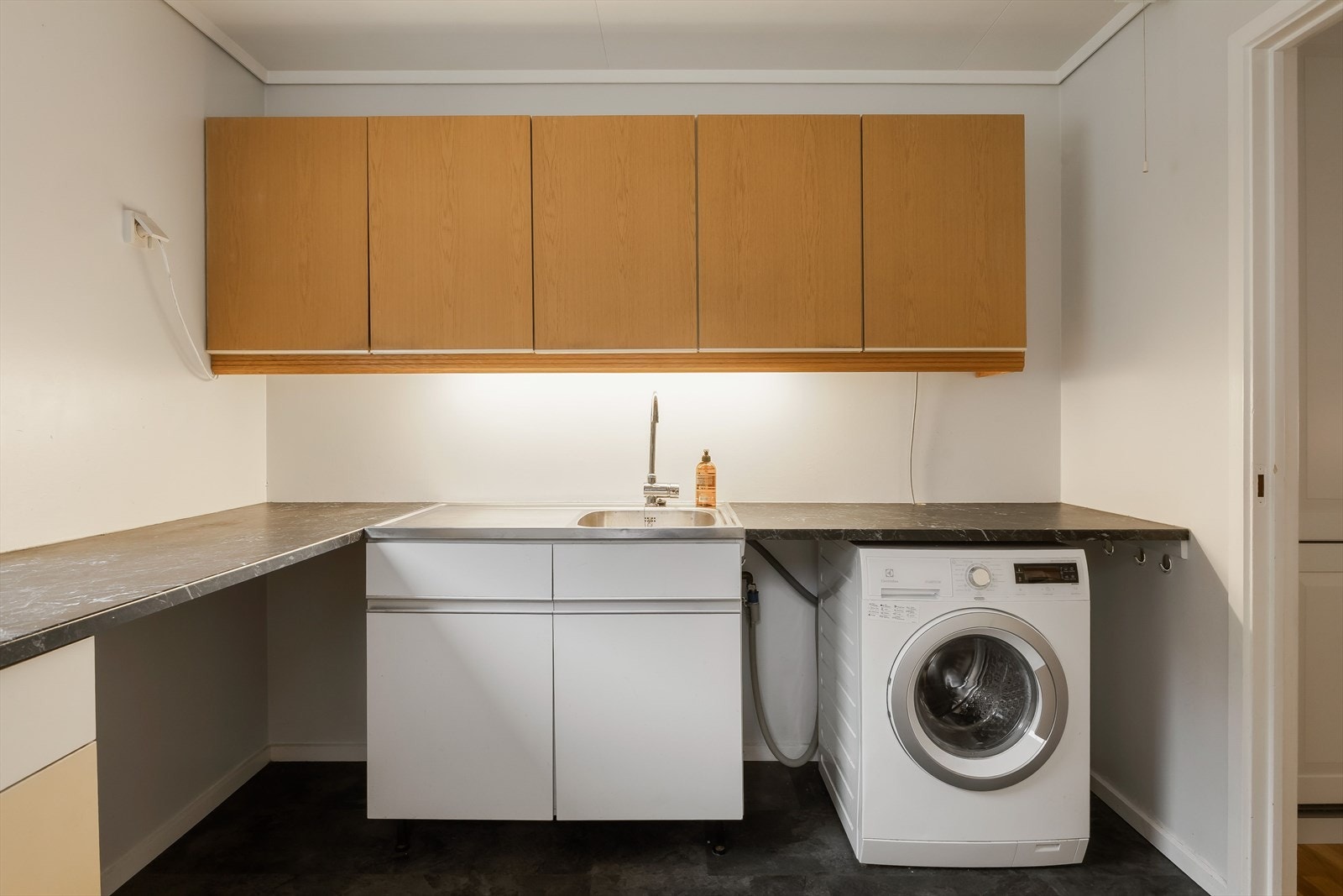 Stort og praktisk vaskerom med god arbeidsflate og oppbevaring - perfekt for familien Galleribilde