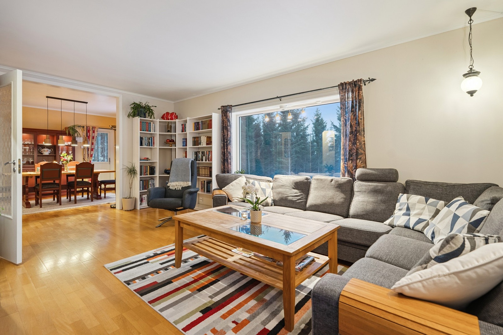 Stue med parkett og store vindusflater mot fjorden. Rommet har vedovn fra 2006 og varmepumpe i hovedetasjen. Galleribilde