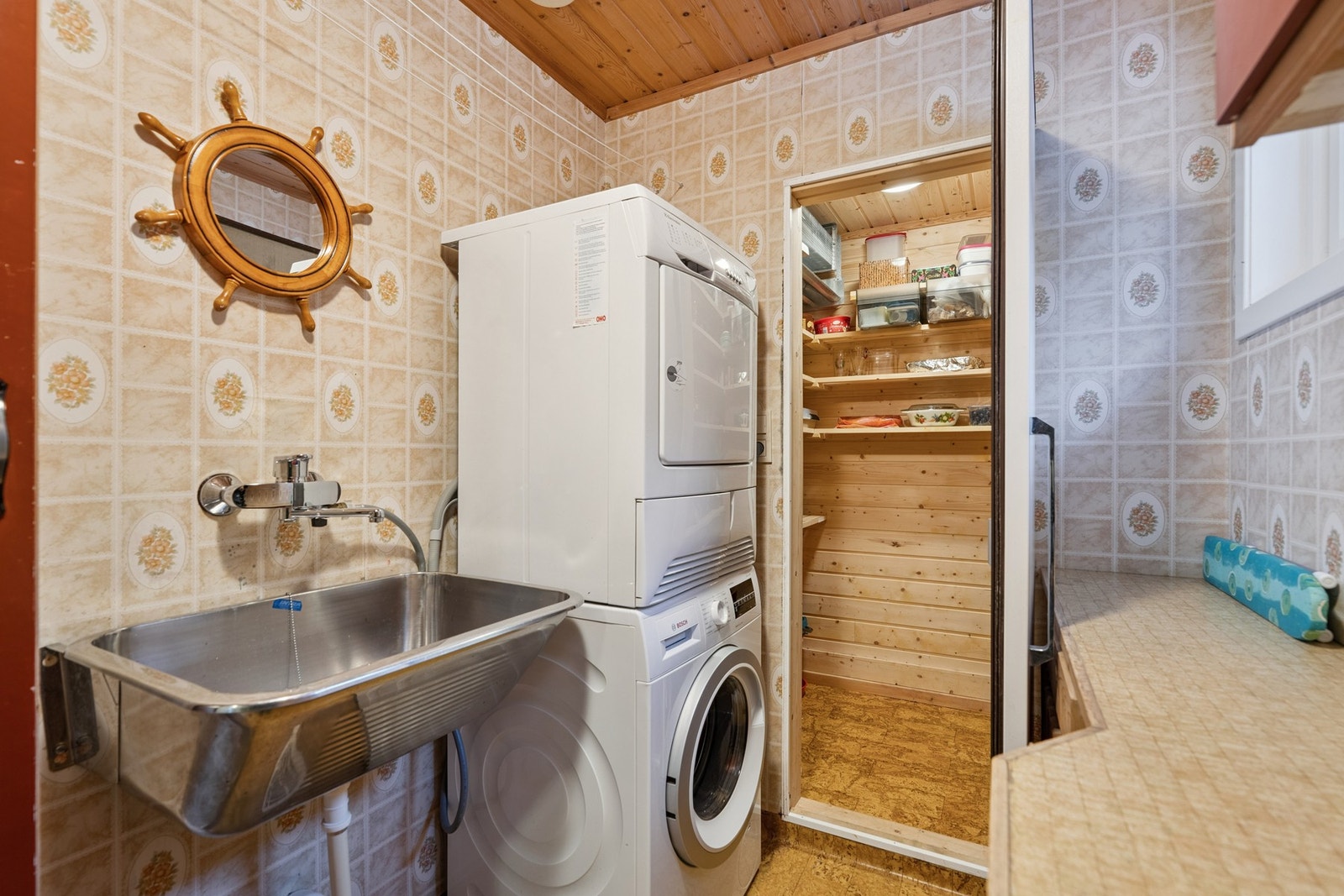 Vaskerom med belegg og varmekabler i gulv. Vegger med våtromstapet og praktisk innredning med vaskekum, skap og opplegg for vaskemaskin og tørketrommel. . Galleribilde