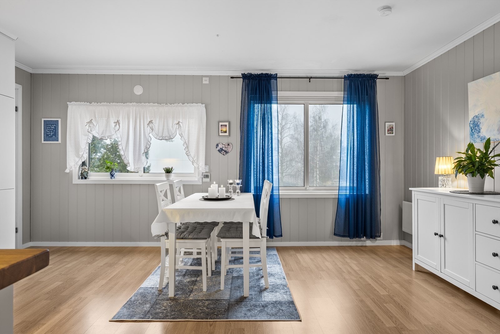 Rommet har laminatgulv som gir et helhetlig og praktisk uttrykk, kombinert med malte MDF-plater på veggene og et malt, slett tak som bidrar til en ren og tidløs atmosfære. Galleribilde