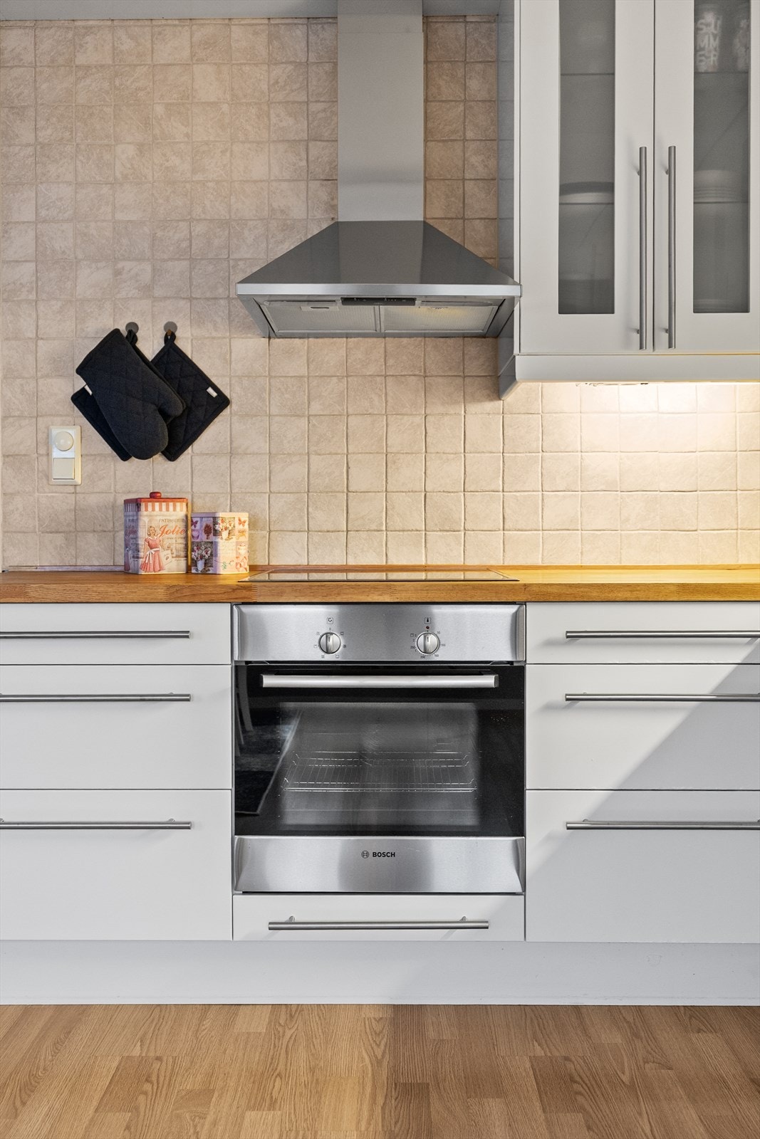 Over benkeplatene er veggene flislagt, noe som både er praktisk i bruk og gir kjøkkenet et gjennomført preg. Galleribilde