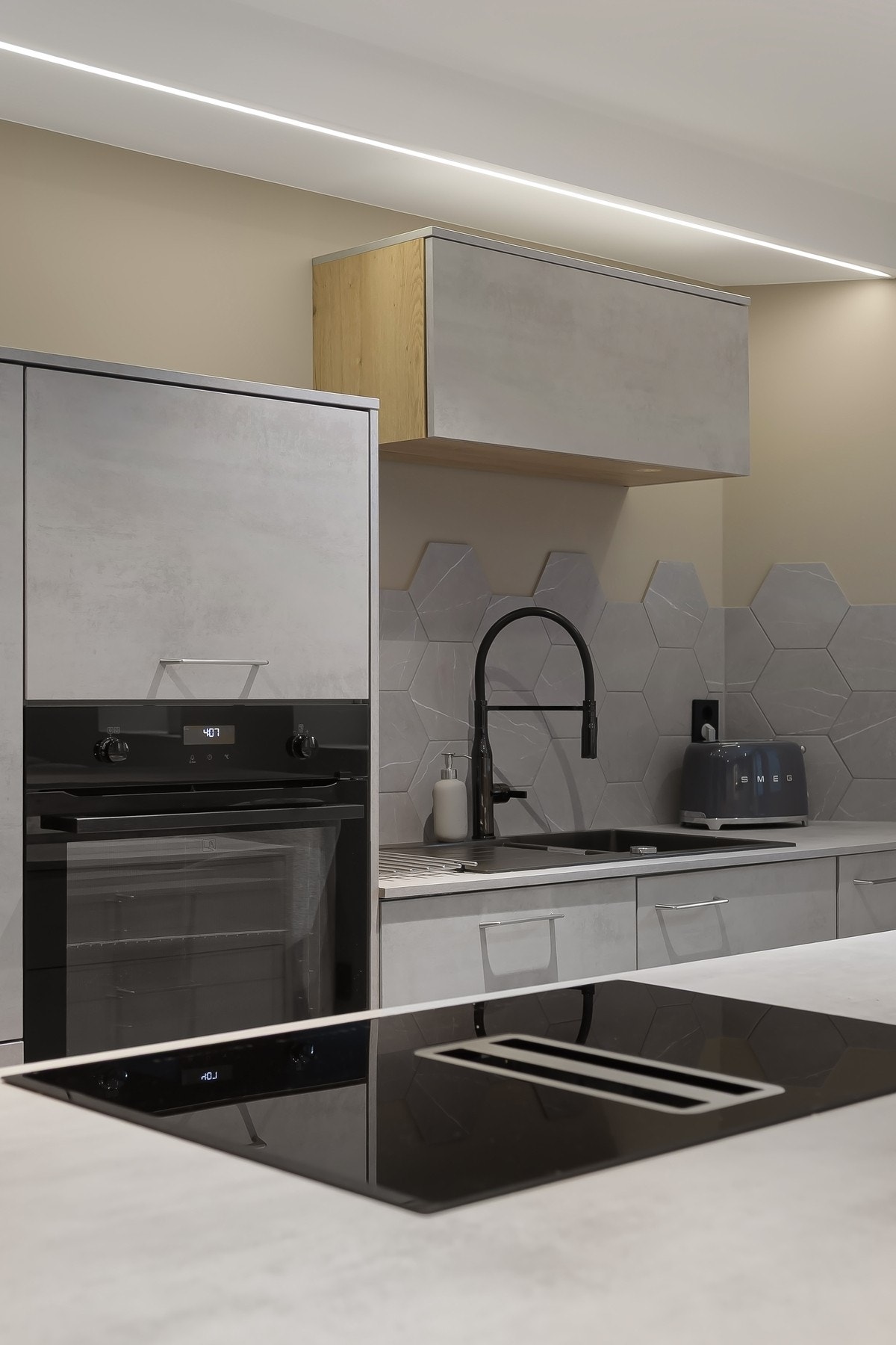 Kjøkkenøy med induksjonstopp og integrert ventilator gir både funksjonalitet og et stilrent uttrykk. Galleribilde