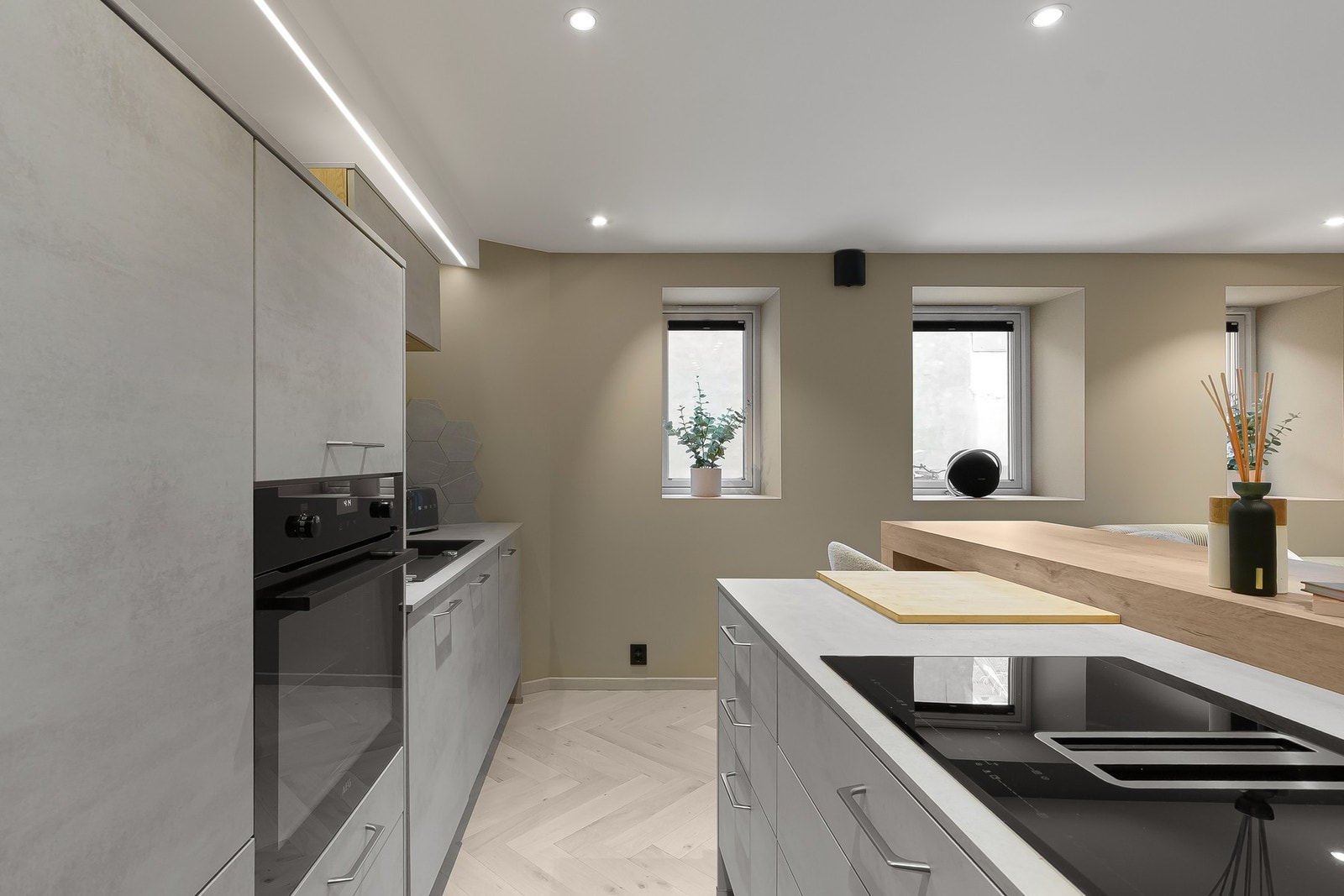 Kjøkkenet kombinerer funksjon og design på elegant vis, med lune fargetoner, gjennomtenkte detaljer og gode soner for både matlaging og hyggelige øyeblikk rundt øya. Galleribilde