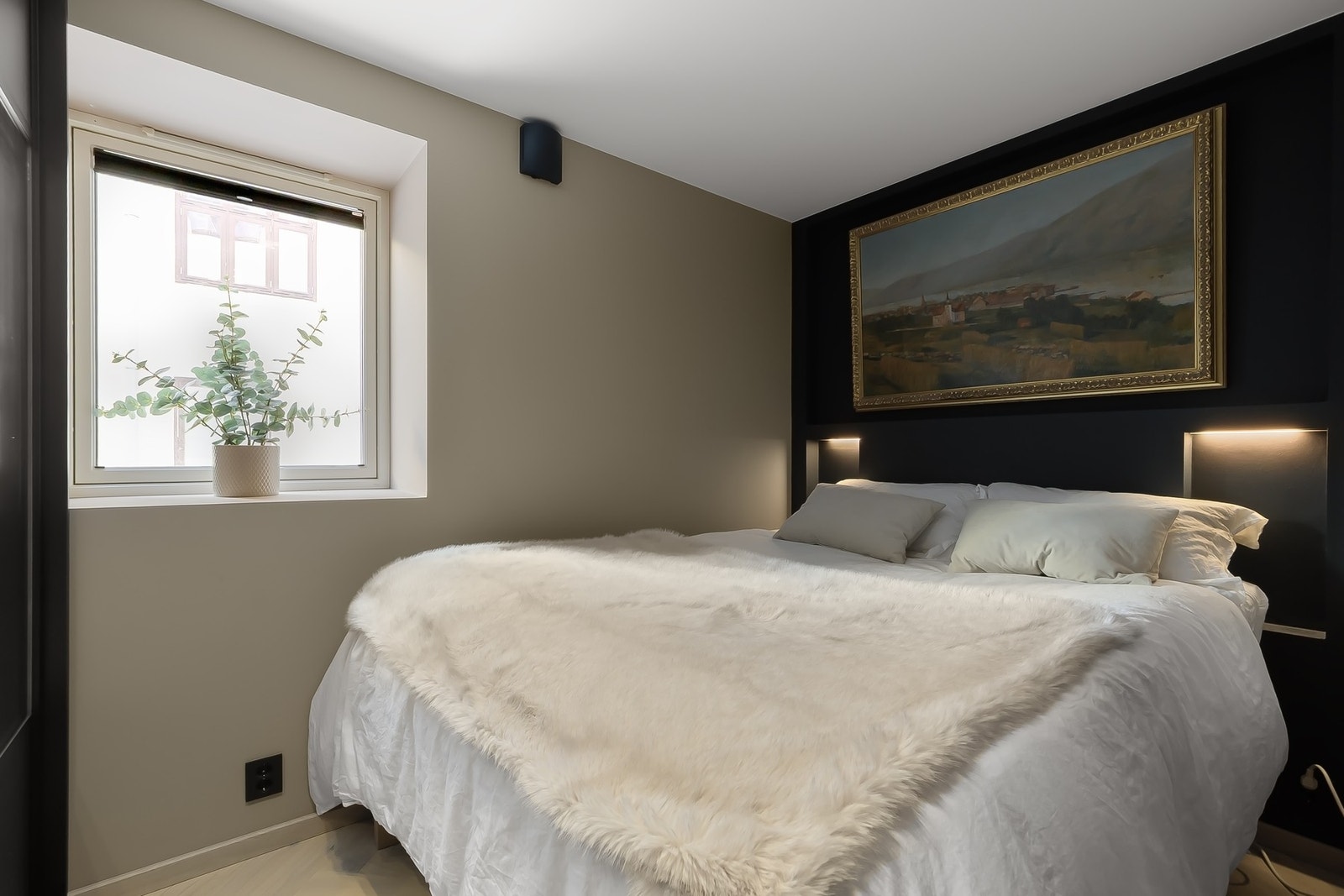 Lunt og pent soverom med plass til dobbeltseng og behagelig stemningsbelysning som skaper en rolig atmosfære. Galleribilde