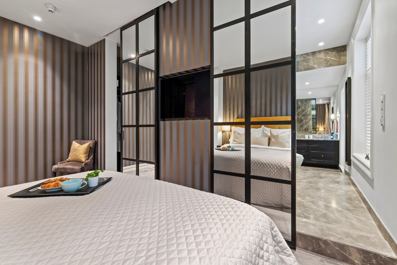 Støpejernsdør og helhetlig materialbruk gir rommet et elegant og solid uttrykk. Galleribilde