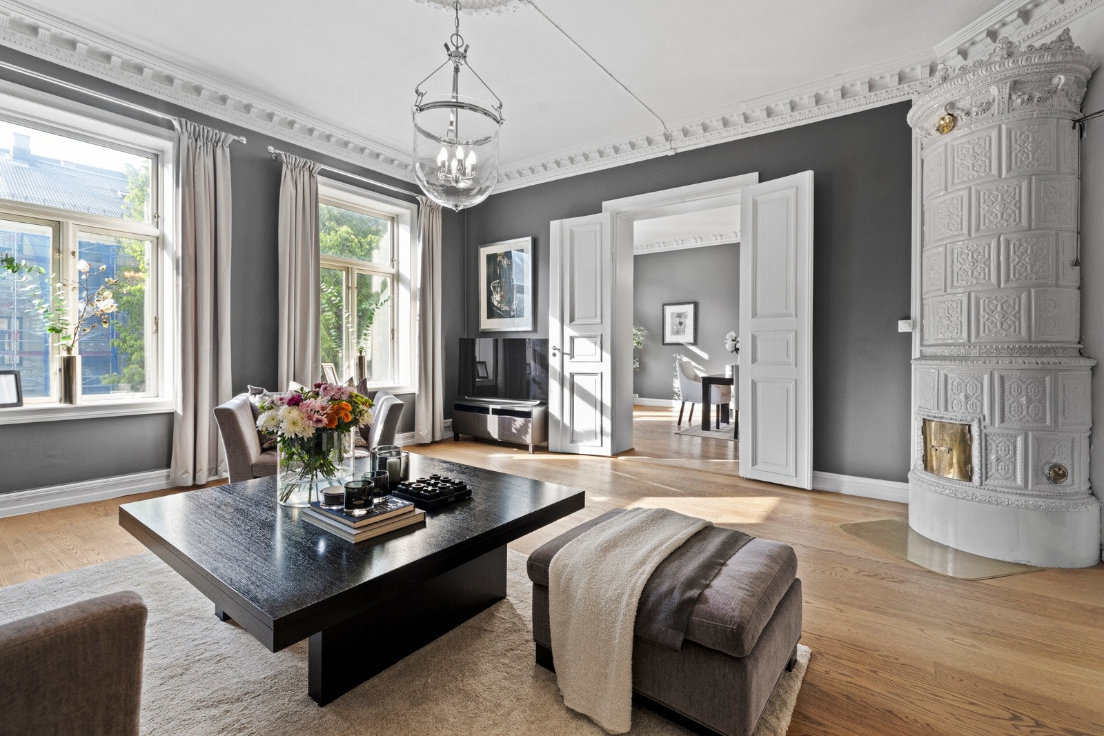 Gulvet er belagt med parkett i amerikansk eik, og de originale, to-fløyede dørene mellom stuene gir en elegant flyt og fleksibel bruk av rommene Galleribilde