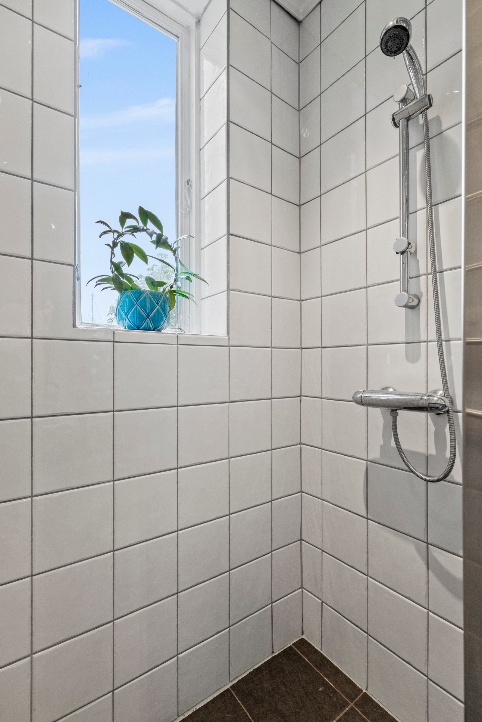 Her finner du servant med servantskap, vegghengt toalett med skjult sisterne og dusjhjørne avgrenset med glassbyggerstensvegg. Galleribilde