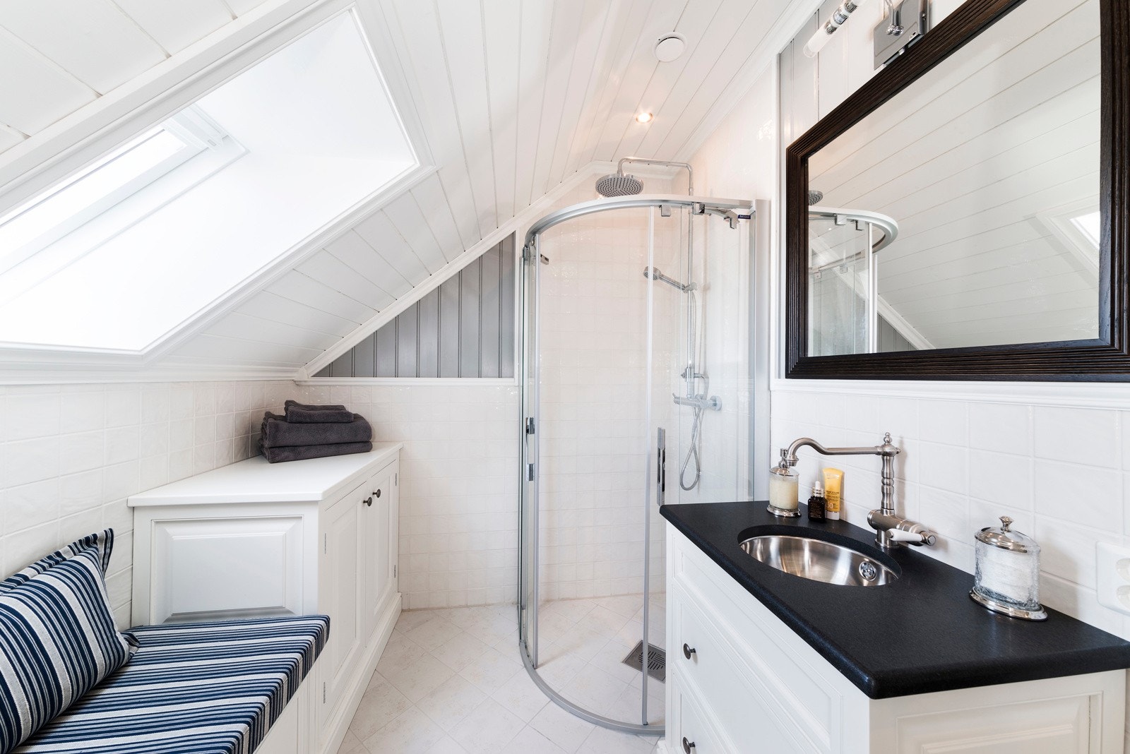 Innredningen inkluderer en nedfelt servant med skap, speil, toalett og en dusjnisje med glassdører. Galleribilde