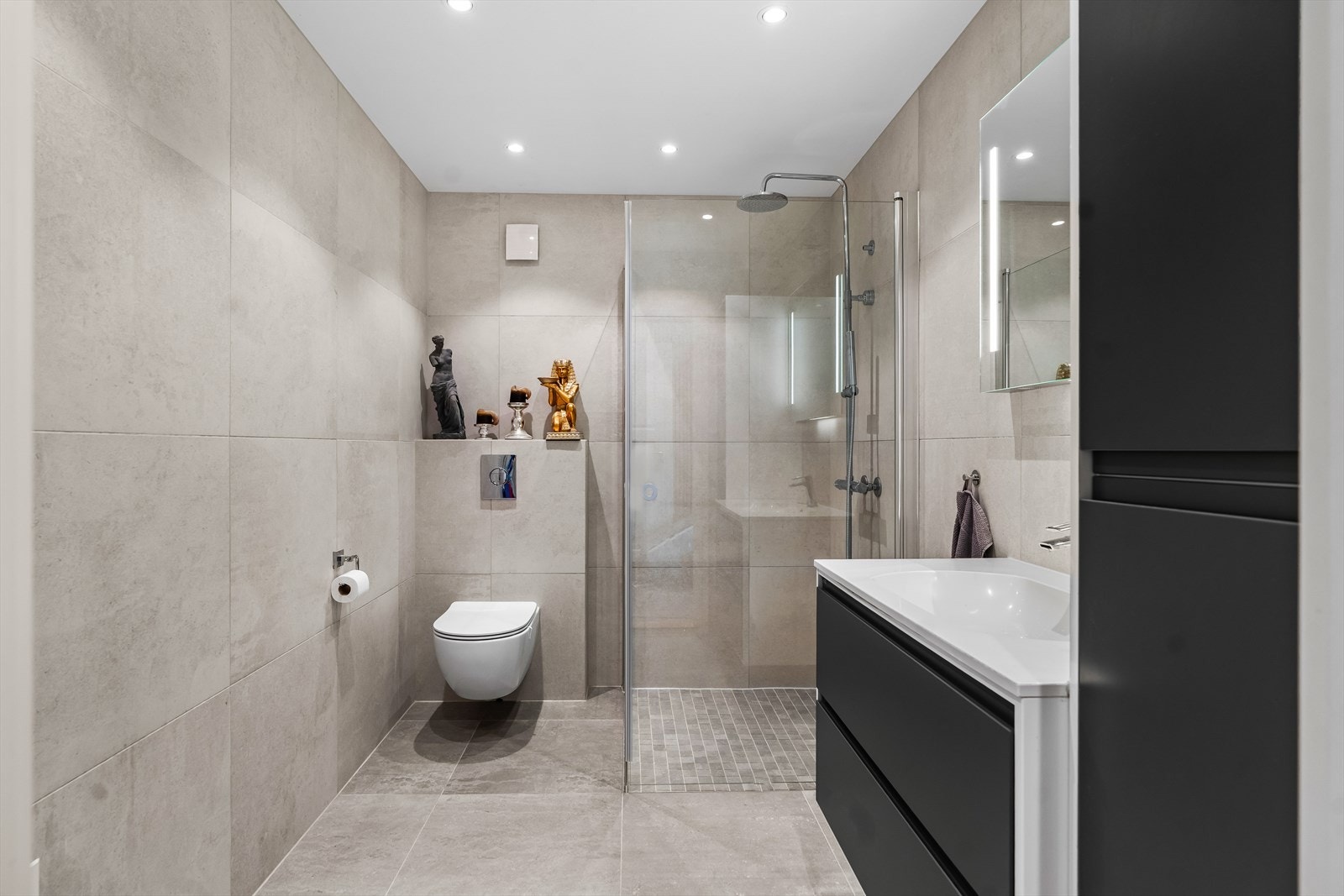 Etasjen har et romslig bad, med flis på gulv og vegger. Det er downlights og malt overflate i himling. I tillegg har badet gulvvarme. Galleribilde