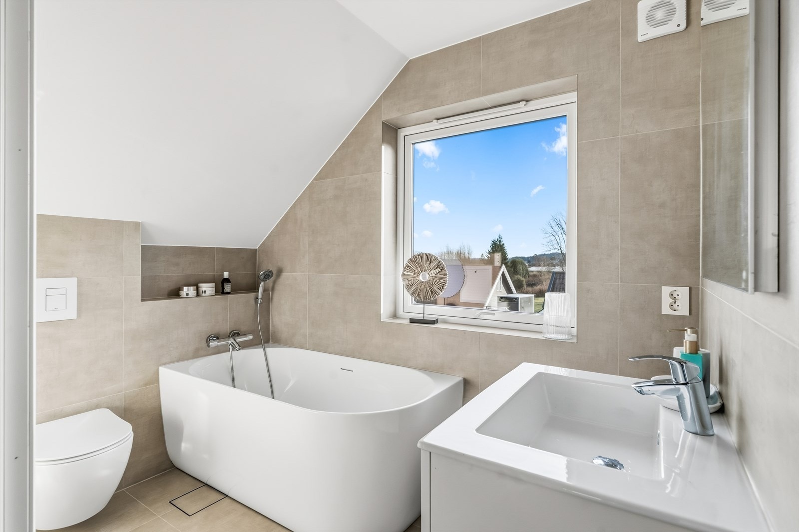 Etasjens baderom har, i likhet med badet i 1. etasje, flislagte vegg- og gulvflater, samt malt overflate i himling. Galleribilde