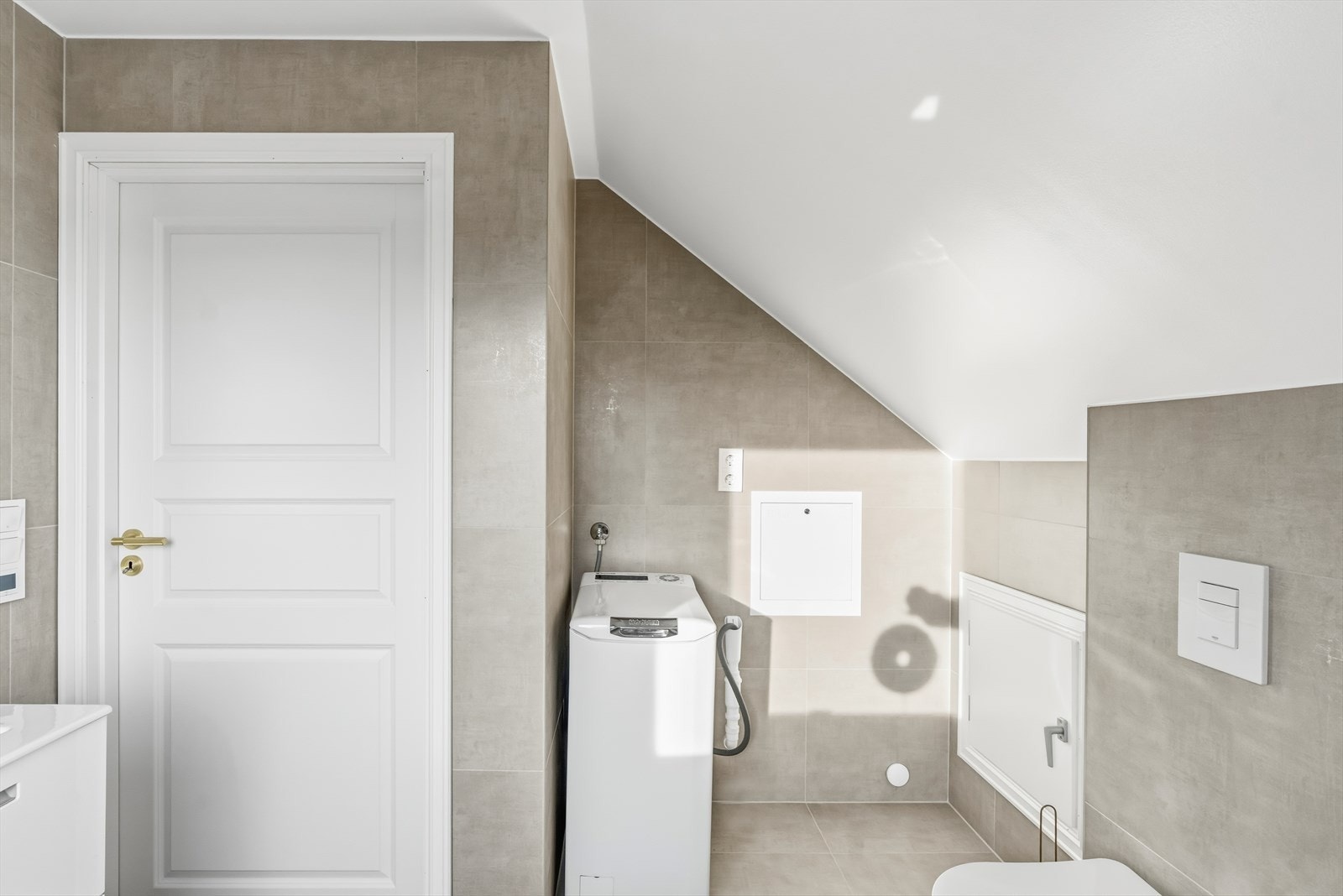 Videre er badet utstyrt med badekar, opplegg for vaskemaskin, mekanisk avtrekk, servantskap, stoppekran, rørfordelingsskap og veggmontert wc. Galleribilde