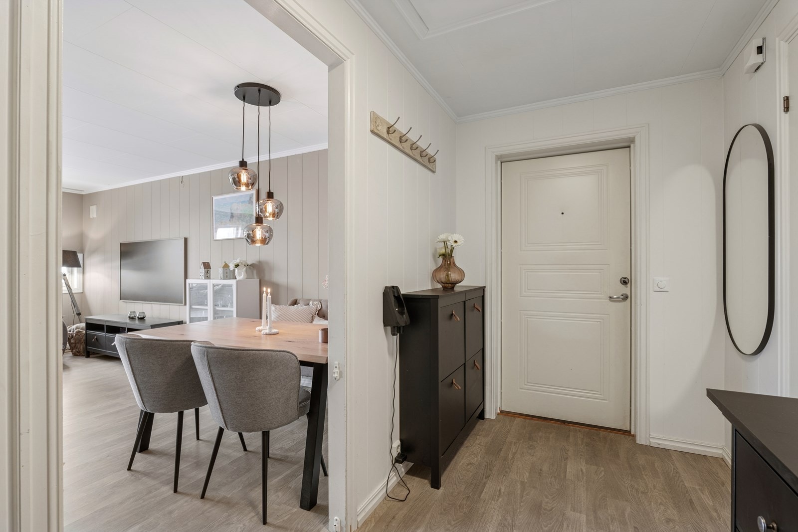 Man kommer inn i romslig entrè med lettstelt laminat på gulv Galleribilde