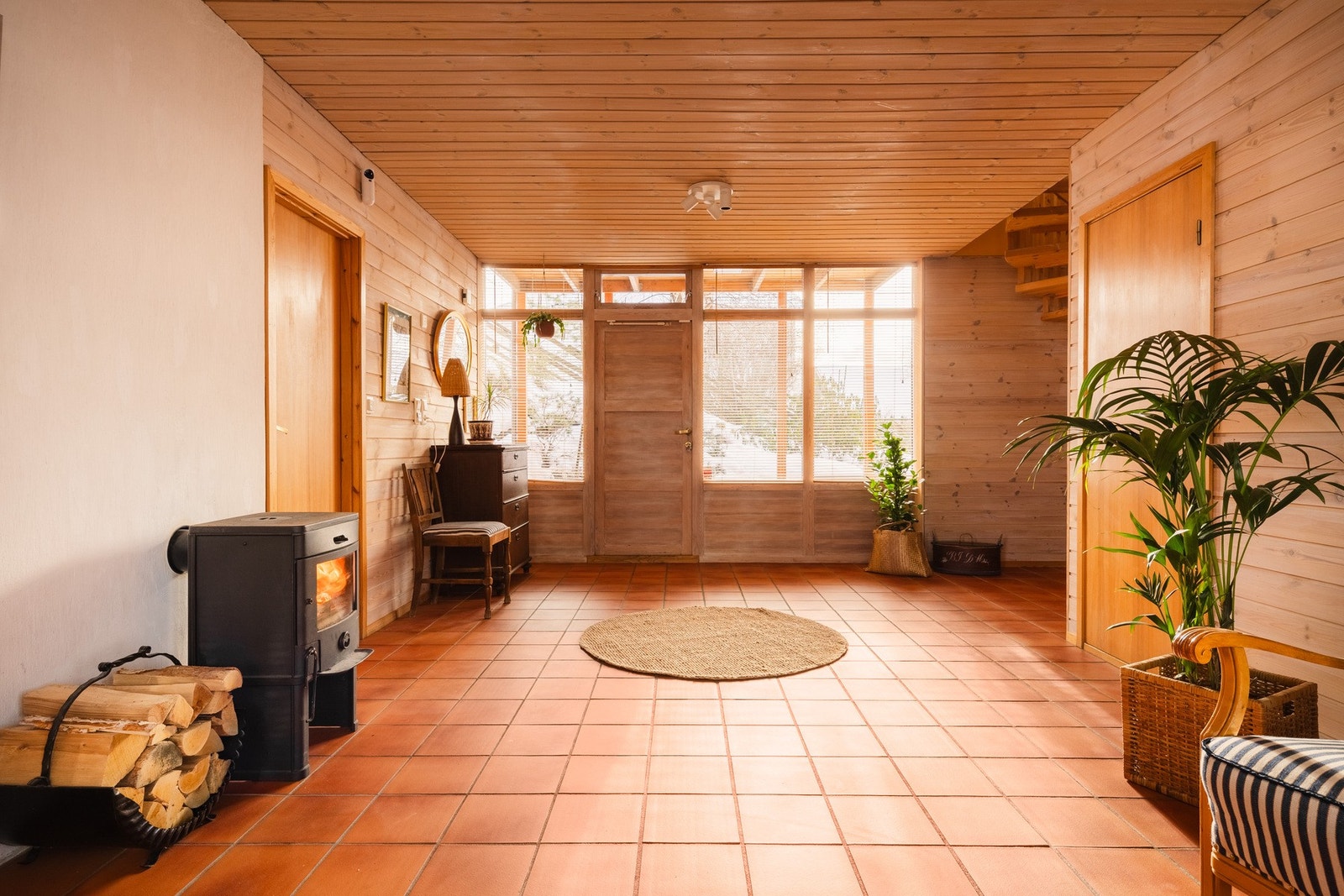 Romslig hall i underetasjen med teglgulv med gulvvarme og peisovn som skaper en lun og hyggelig atmosfære. Hallen gir gode møbleringsmuligheter og kan brukes som mer enn bare gjennomgangsrom. Galleribilde