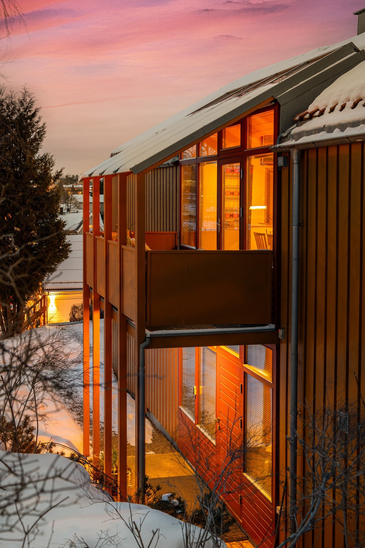 Stemningsfullt eksteriørbilde som fremhever boligens karakter og de store vindusflatene på en flott måte. Dette er en bolig med personlighet, varme og et uttrykk som skiller seg ut. Galleribilde