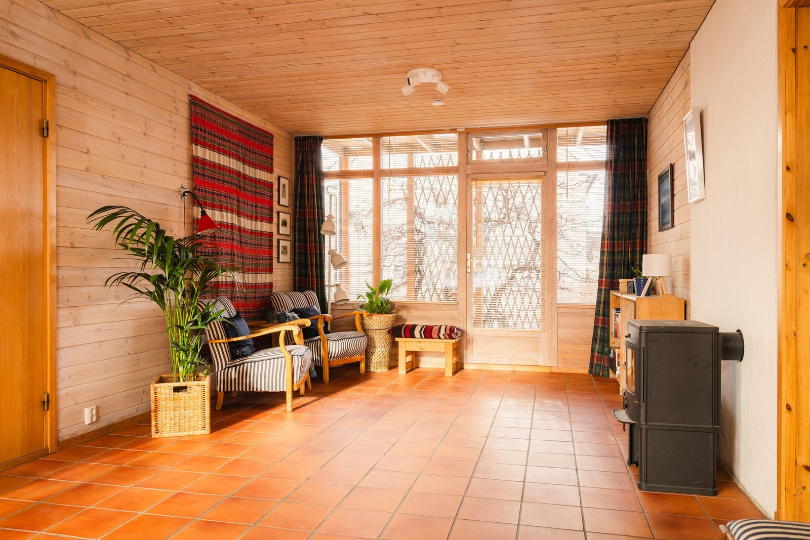 Romslig hall i underetasjen med teglgulv med gulvvarme og peisovn som skaper en lun og hyggelig atmosfære. Hallen gir gode møbleringsmuligheter og kan brukes som mer enn bare gjennomgangsrom. Galleribilde