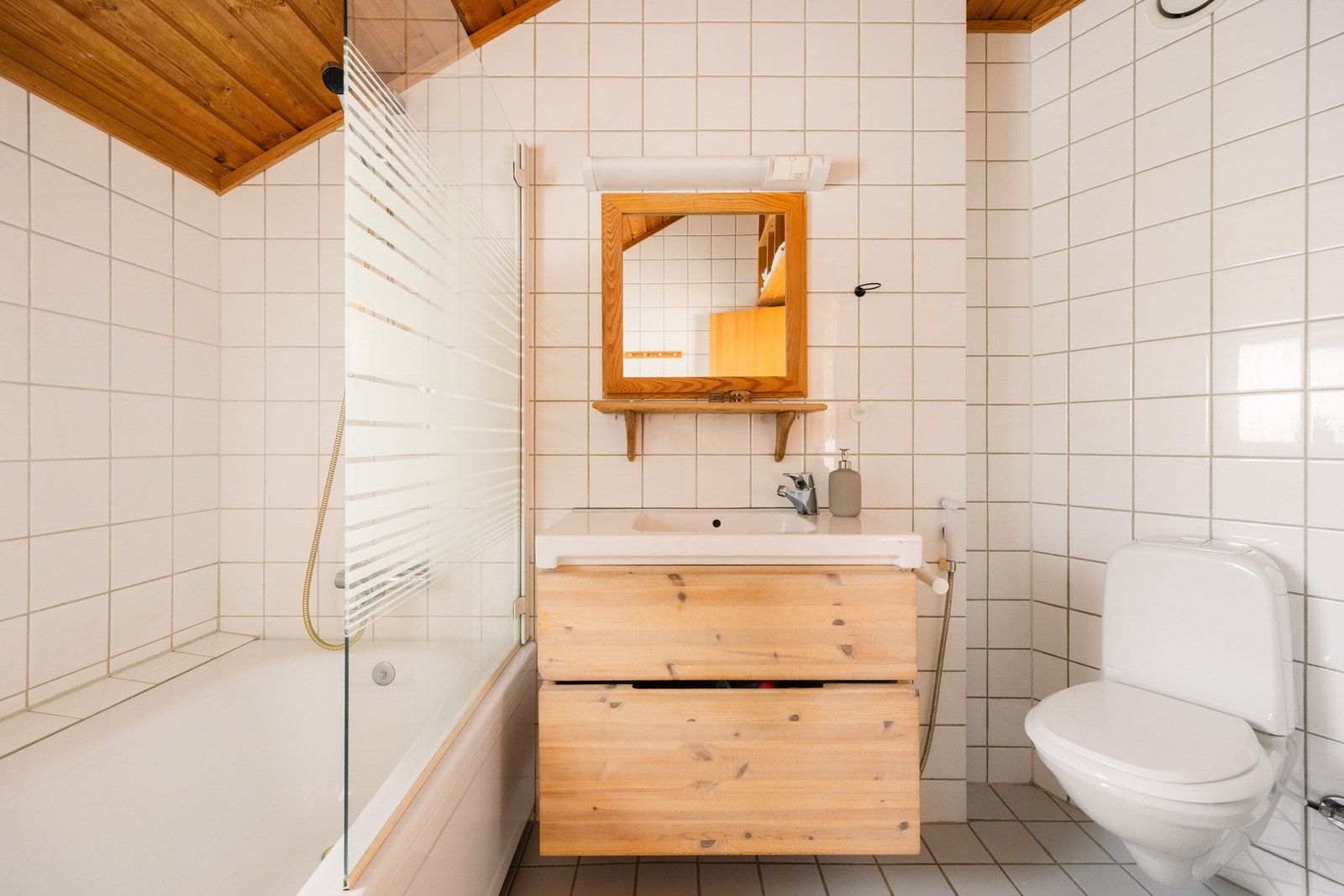 Flislagt bad i hovedetasjen med gulvvarme, badekar, servantinnredning og WC. Et romslig og funksjonelt baderom med alt du trenger samlet i hovedetasjen. Galleribilde