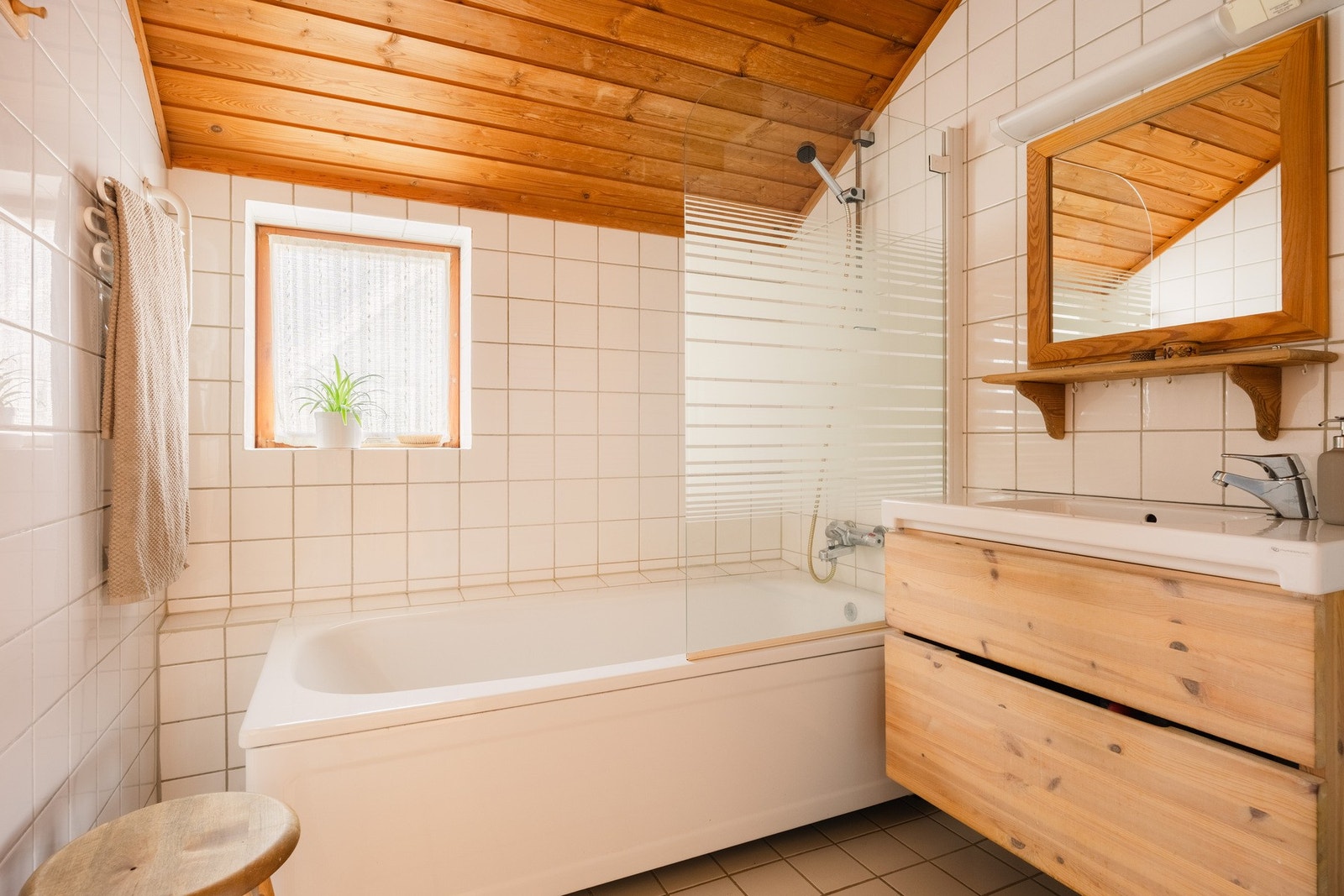 Flislagt bad i hovedetasjen med gulvvarme, badekar, servantinnredning og WC. Et romslig og funksjonelt baderom med alt du trenger samlet i hovedetasjen. Galleribilde