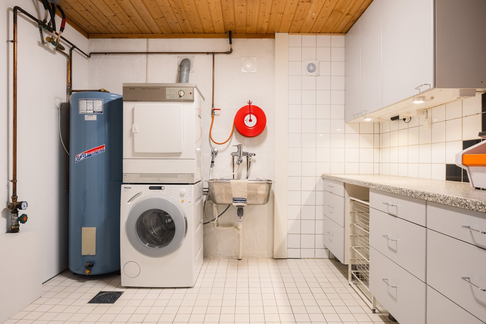 Vaskerom med arbeidsbenk, opplegg for vaskemaskin og god lagringsplass. Her har du et rom som gjør hverdagslogistikken enkel og ryddig. Galleribilde