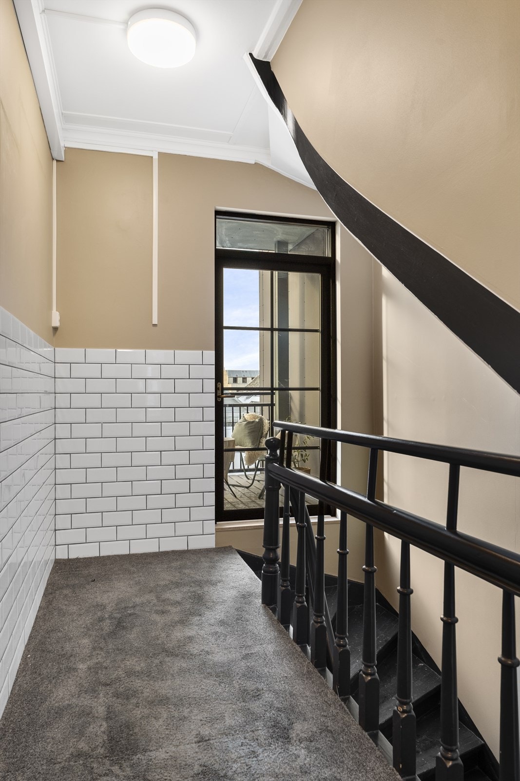 Fra felles trapperom har en utgang til den vestevendt terrassen tilhørende denne leiligheten Galleribilde