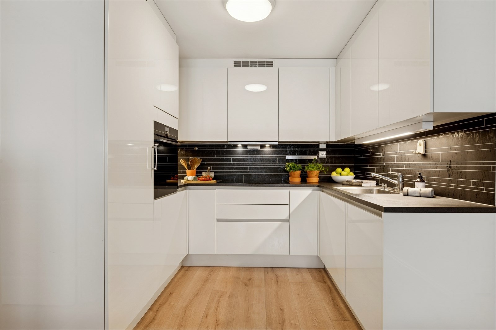 Rikelig med skap- og benkeplass! Induksjonstopp, stekeovn, oppvaskmaskin og kjøleskap og fryseskap er integrert i innredningen. Galleribilde