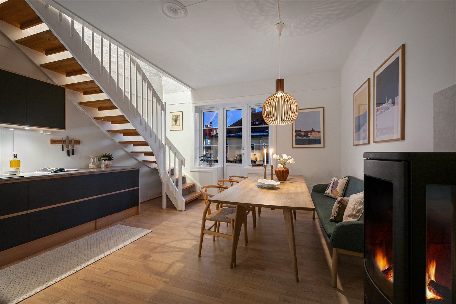 Kjøkkenet ligger i underetasjen, med utgang til brannbalkong mot bakgården. Her får du peis, stort spisebord og en lun sone perfekt for hverdagsliv og lange middager. Galleribilde