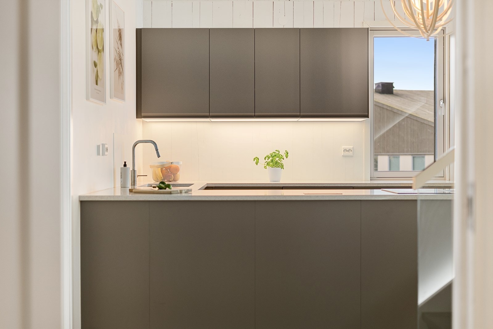 Stilig og moderne kjøkken fra 2025 med steinplate og integrerte hvitevarer som kjøleskap, oppvaskmaskin, platetopp og stekeovn. Galleribilde