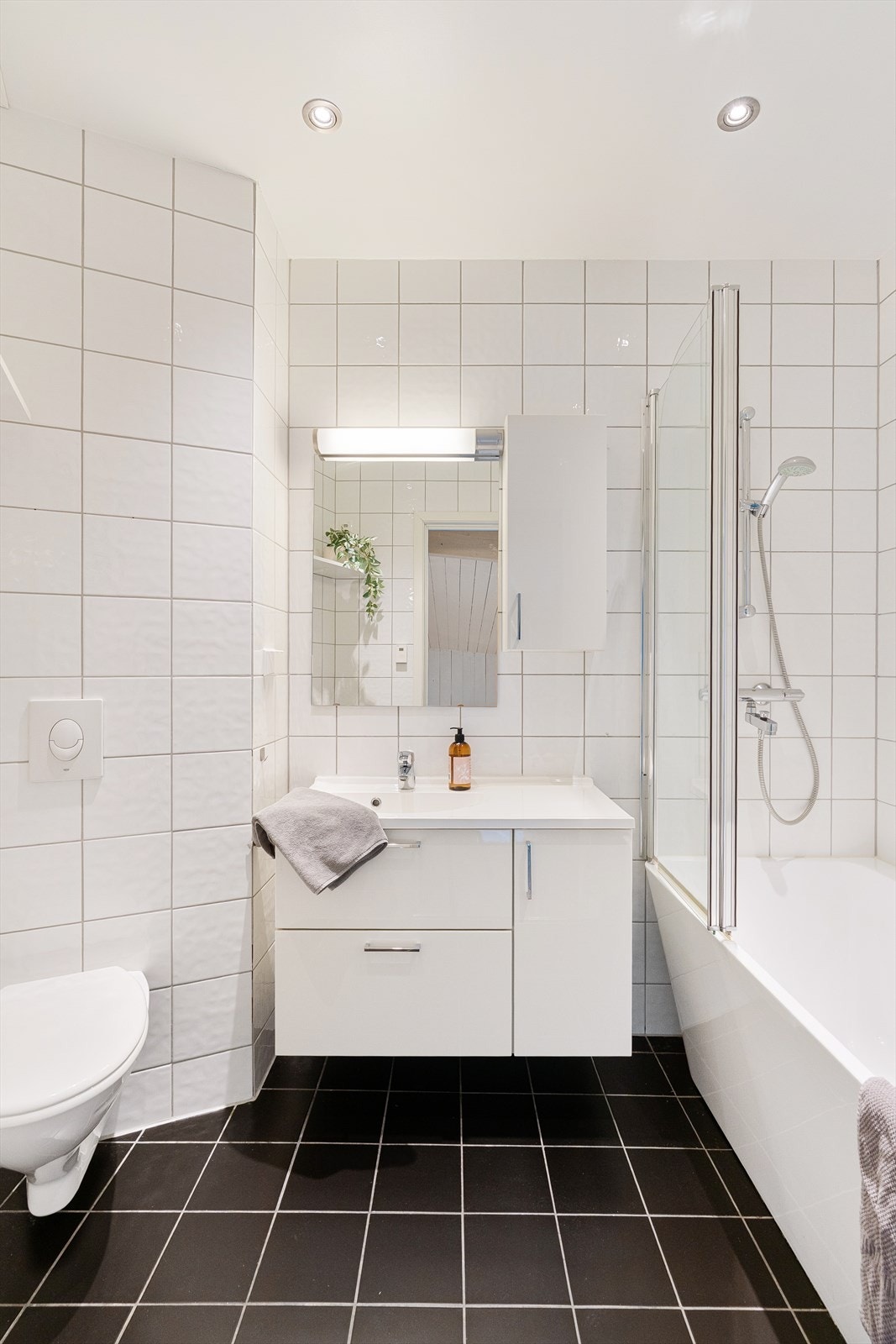 Badet har innredning med nedfelt servant, veggmontert toalett og badekar. Galleribilde