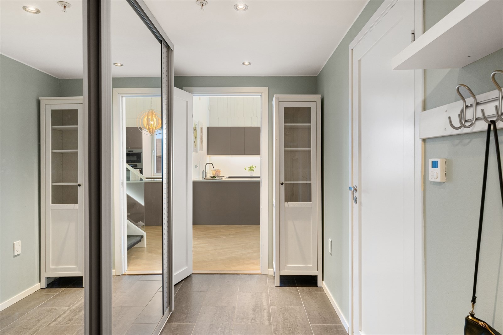 Man ønskes velkommen til en moderne gang med romslig skyvedørsgarderobe. Galleribilde