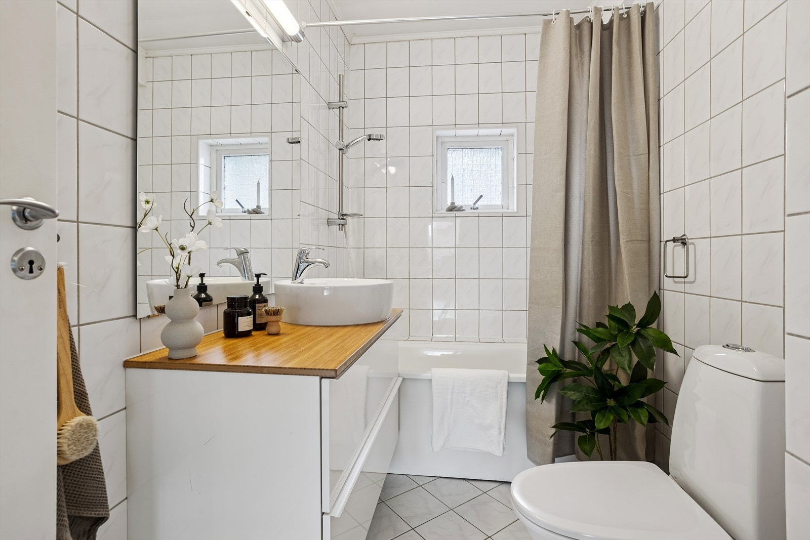 Badet er helfliset og utstyrt med varme i gulv, toalett, servant med innredning og badekar med dusjfunksjon. Galleribilde