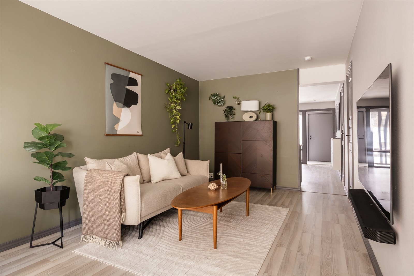 Stuen er malt i en lun grønnfarge og ligger naturlig adskilt fra kjøkkenet. Galleribilde