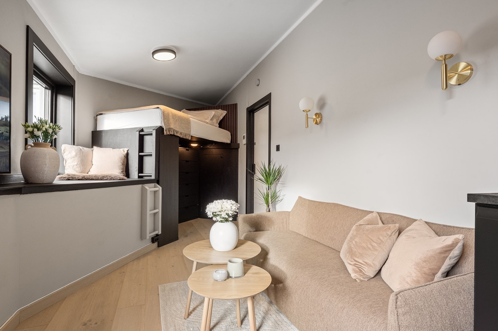 Rommet er smart og arealeffektivt innredet med en plassbygget hems som utnytter takhøyden maksimalt. Sengen er hevet over gulvet og gir rom for oppbevaring under. Galleribilde