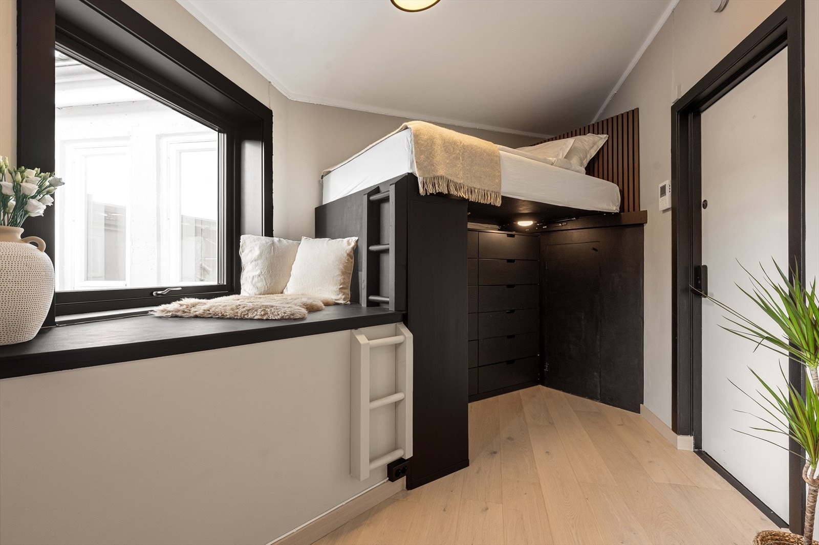 Oppbevaringsplass under sengen med integrerte skuffer og skap i mørk utførelse samt et eget "rom" i hjørnet med praktisk plass til støvsuger etc. Galleribilde