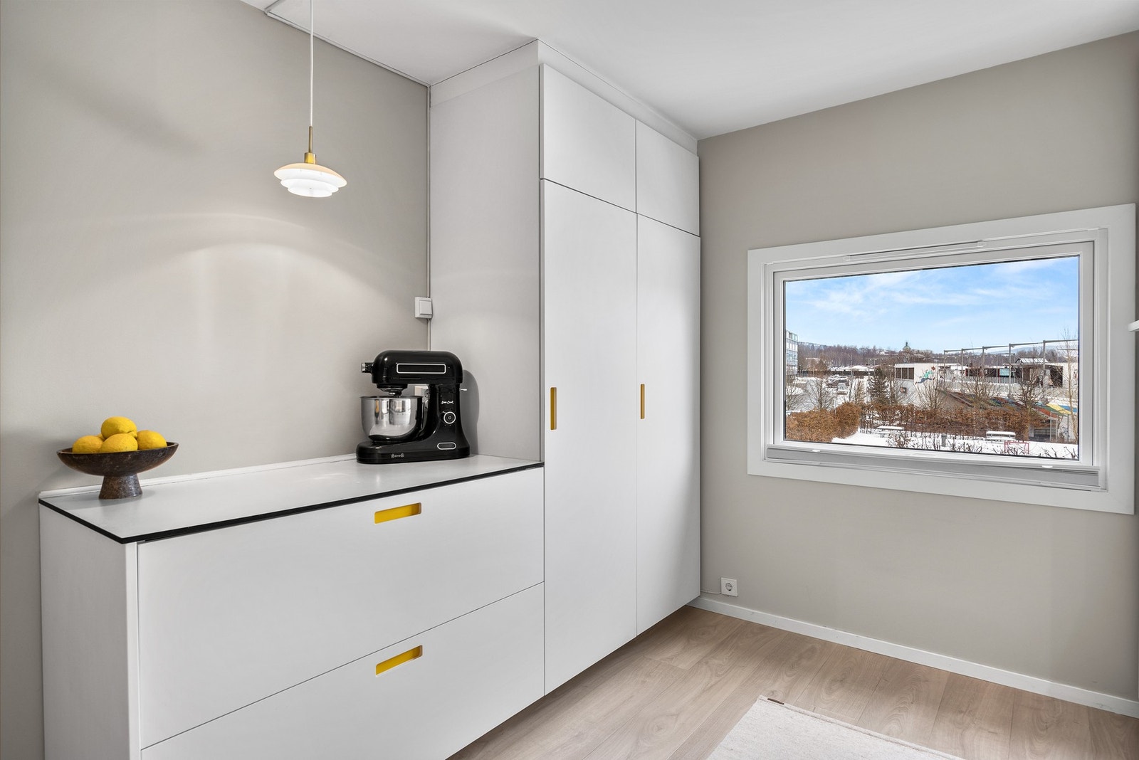 Et stort vindu i enden av kjøkkenet slipper inn det naturlige lyset og gjør rommet til et hyggelig arbeidsrom for tilberedning av måltidene. Galleribilde