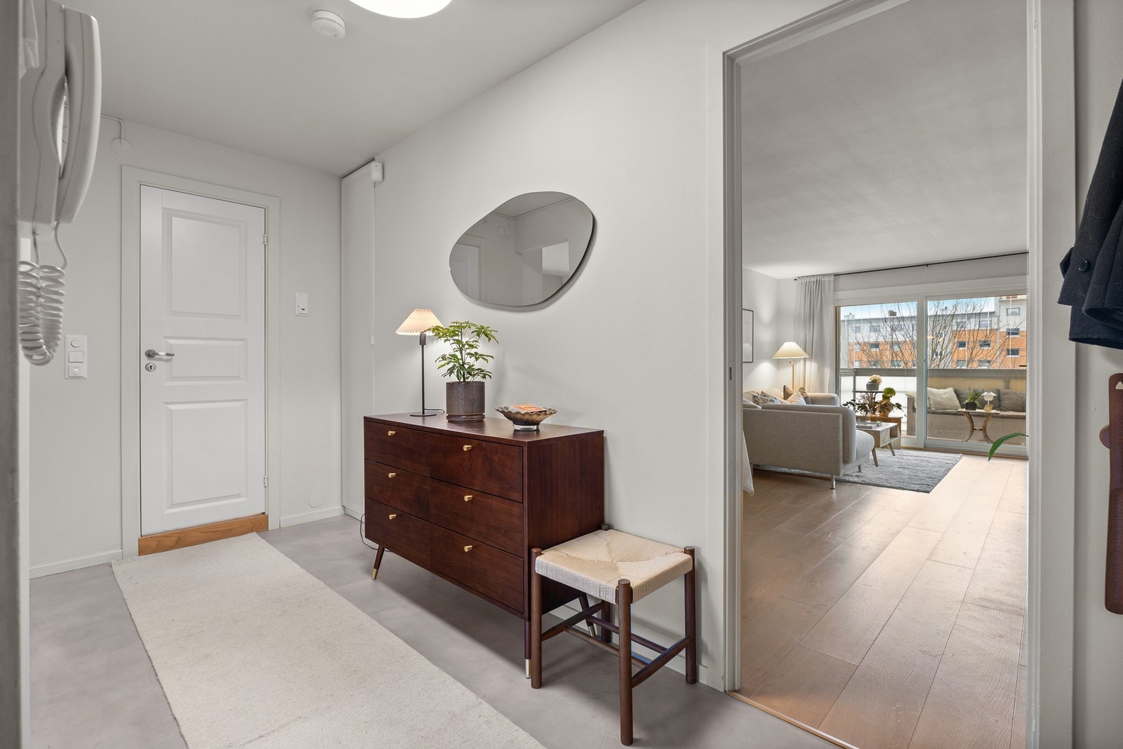 Innbydende entré med mikrosement over et flislagt gulv med varmekabler. Plass til oppbevaring av ytterbekledning. Galleribilde