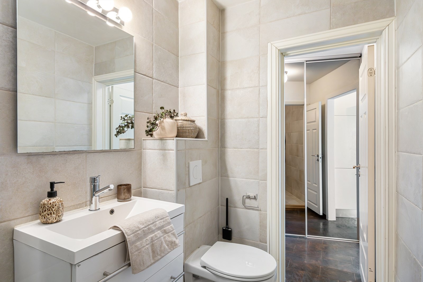 Badet består av servantskap med nedfelt servant, speil med lys over, vegghengt klosett og dusjkabinett. Galleribilde