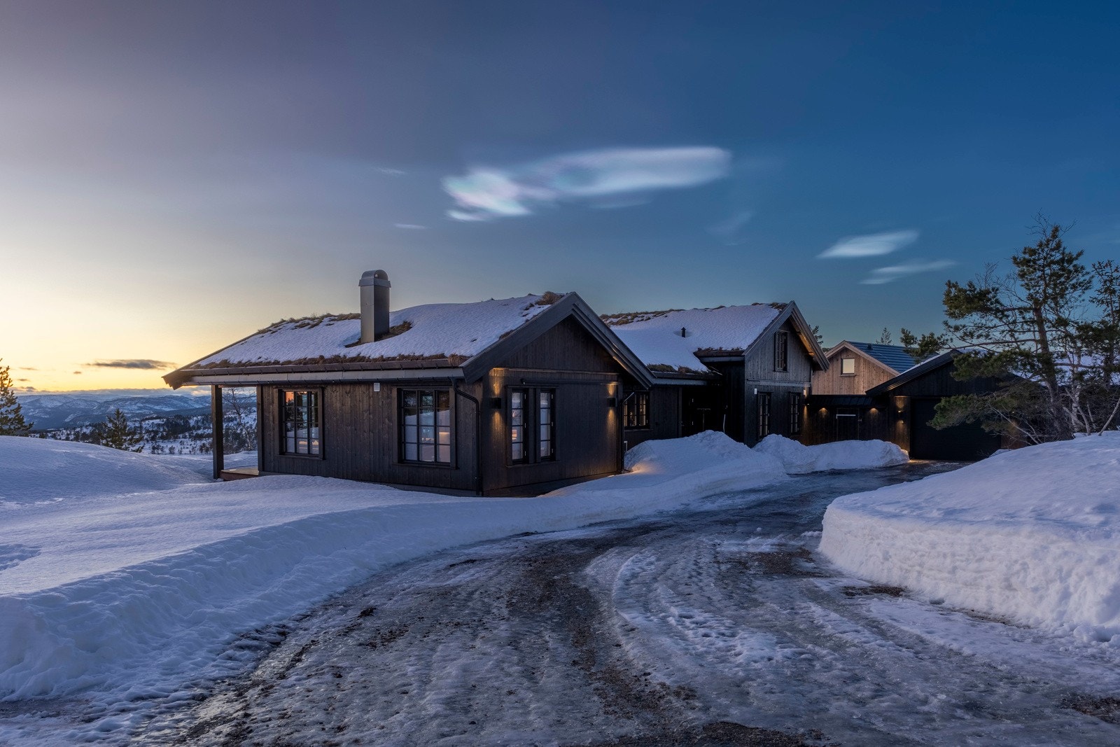 Stemningsbilde av hytta i skumringen - utvendig belysning fremhever den lune hyttefølelsen. Galleribilde