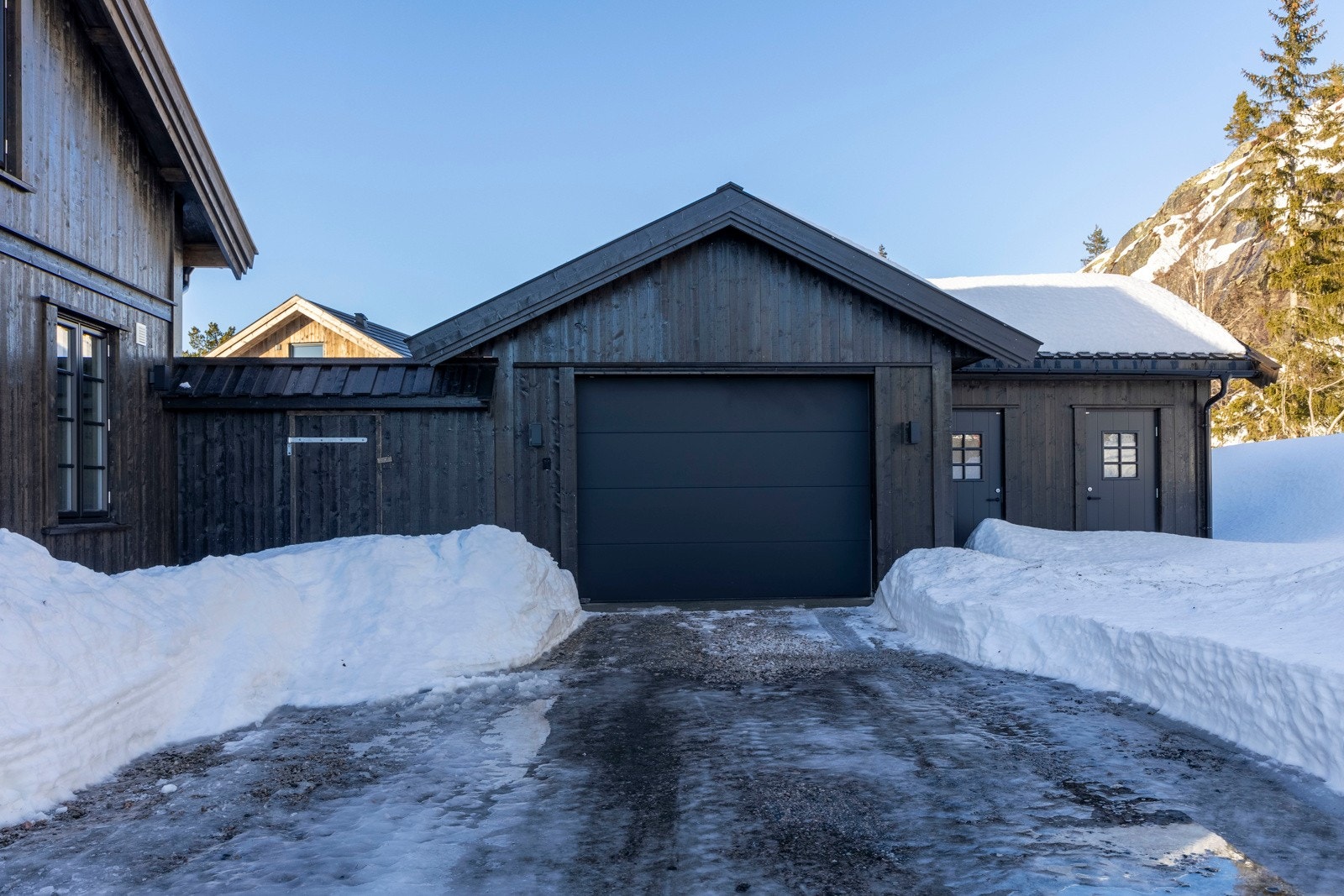 Dobbeltgarasje med innvendig bod. Garasjen er bygget av samme materialer som hytta utvendig over grunnmur. Galleribilde