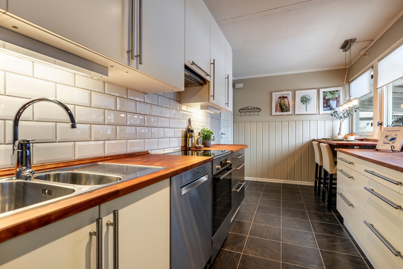 Videre er det belysning over benken, samt flisfelt mellom overskap og kjøkkenbenk som gir et stilfullt preg. Galleribilde