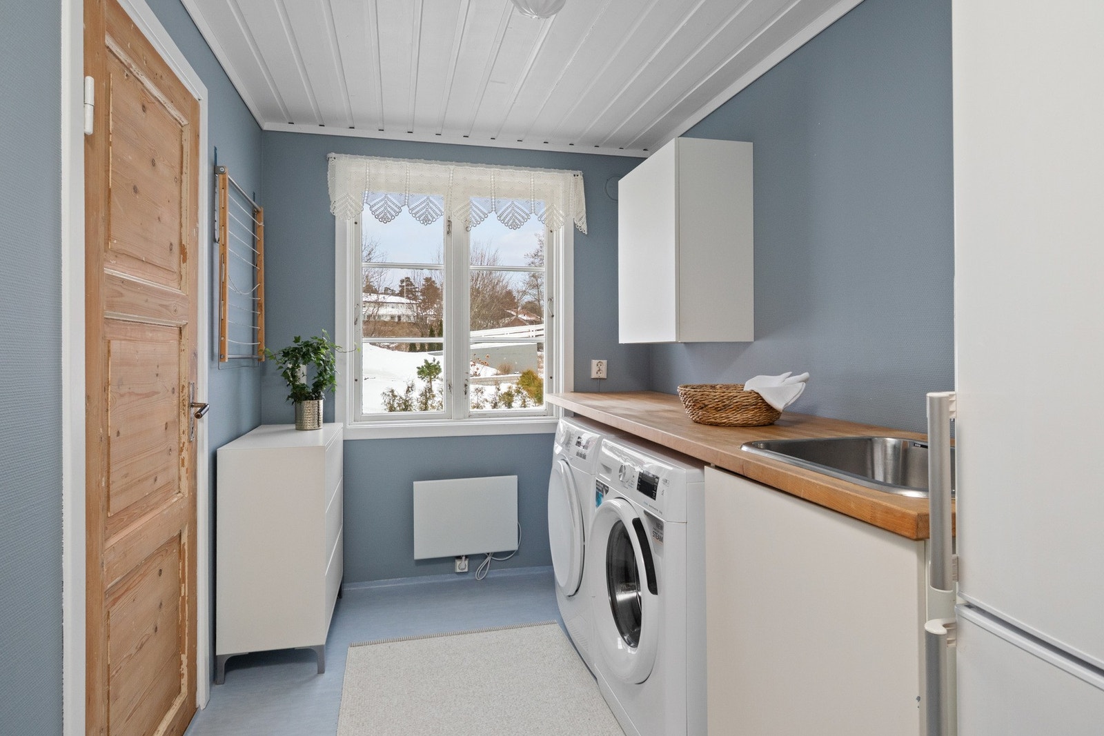 Vaskerommet ligger praktisk til i 1. etasje og har blått våtromsbelegg på gulv samt malte vegger i matchende fargetone. Galleribilde