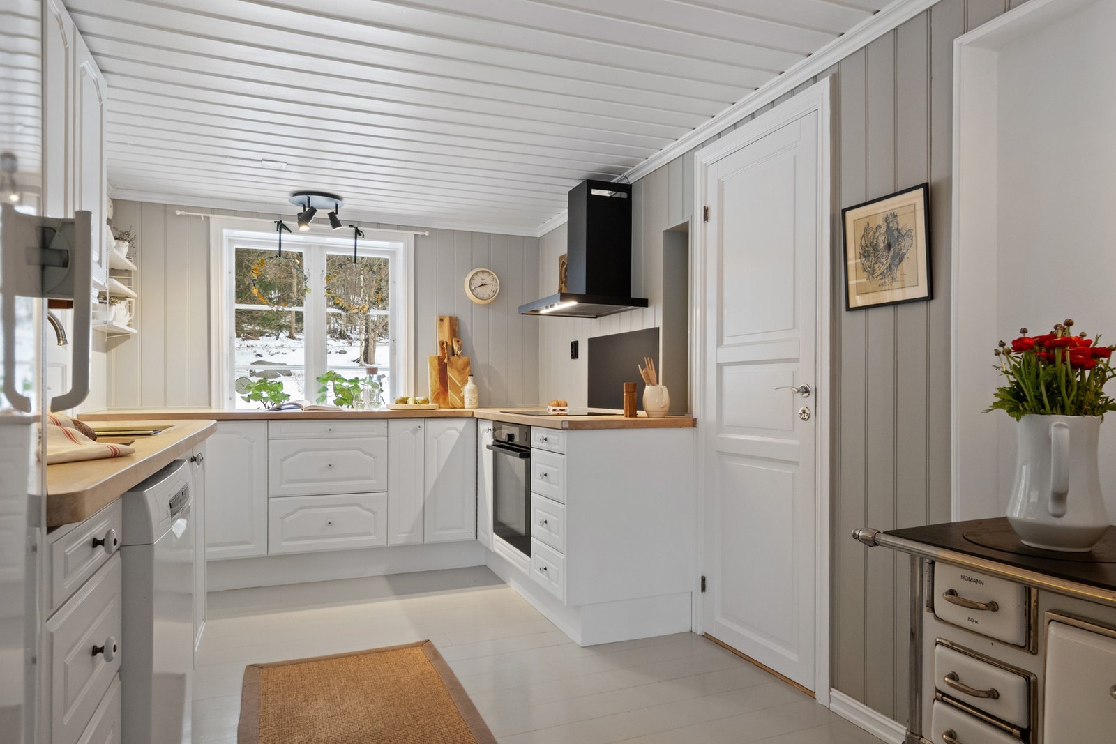 Kjøkkenet holder en klassisk stil som kler boligens alder og uttrykk. Platetopp og stekeovn er integrert i innredningen. Galleribilde